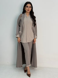 A set of beige abaya that includes matching trousers, coat abaya, inner top and sheila. This abaya set is perfect for travels and corporate events.