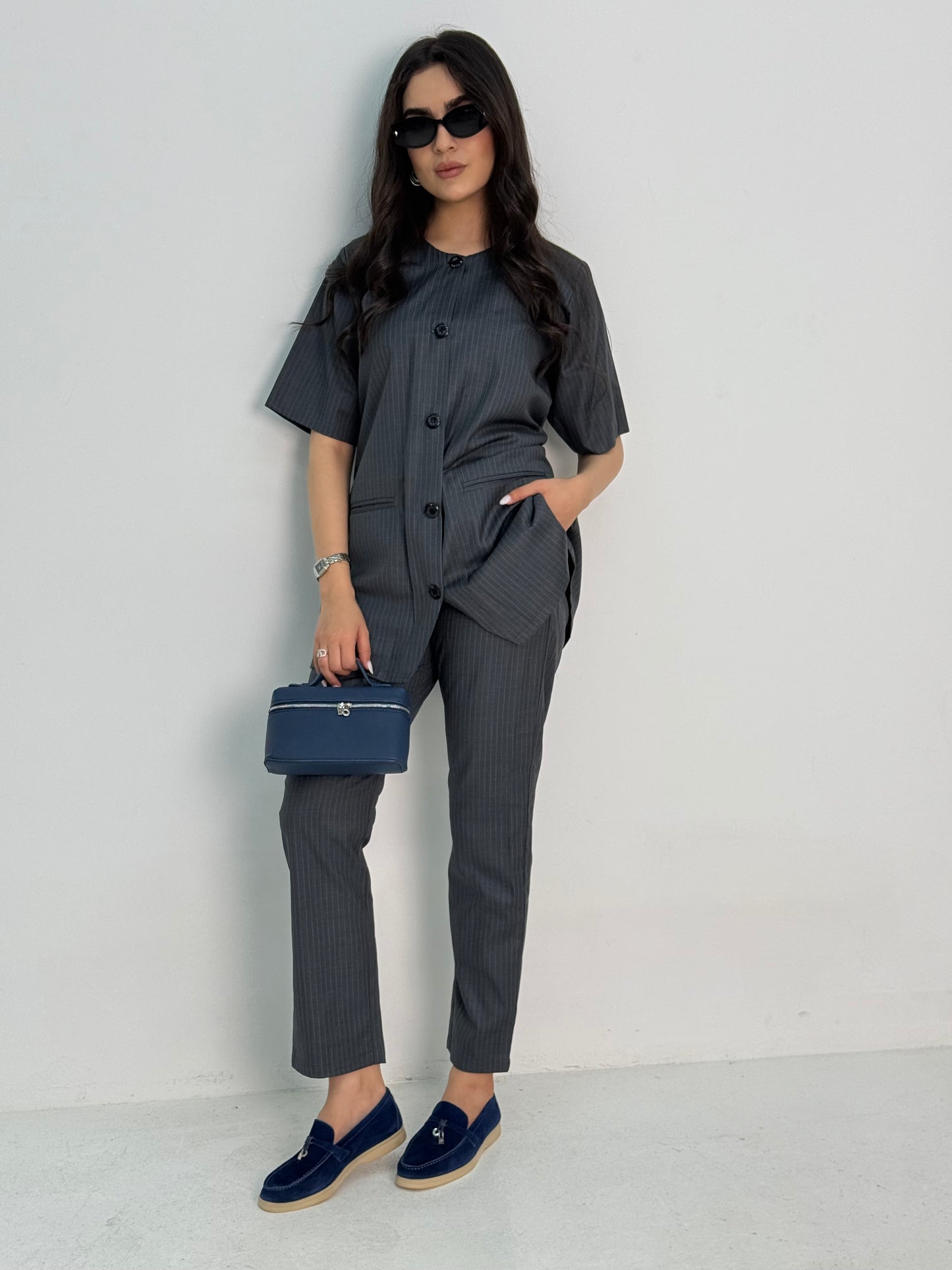 A dark navy pinstripe 4 piece abaya set that includes a coat abaya, matching trouser, waistcoat top and sheila. This abaya set is perfect for daytime formal events or office wear and travel.