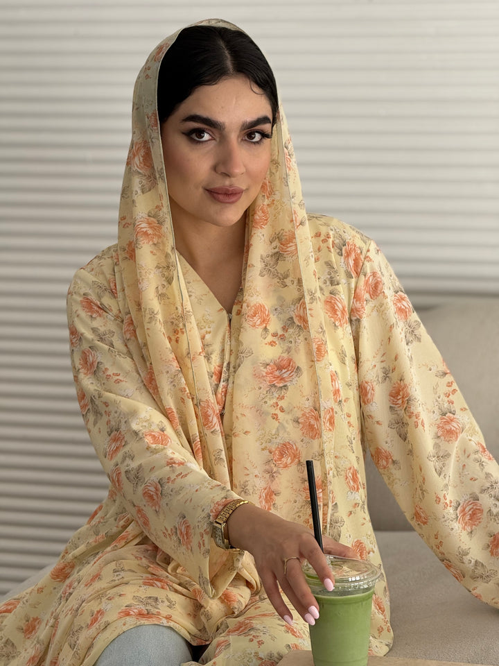 A soft yellow floral chiffon abaya, an elegant abaya that is perfect for summer, daytime events, artistic gatherings.