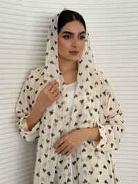 A cream heart print chiffon abaya, an elegant abaya that is perfect for summer, daytime events, and brunch.