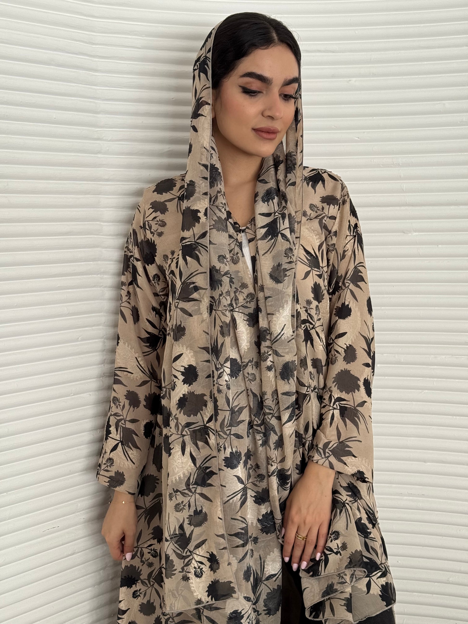A beige and black floral chiffon abaya, an elegant abaya that is perfect for summer, daytime events, and brunch.