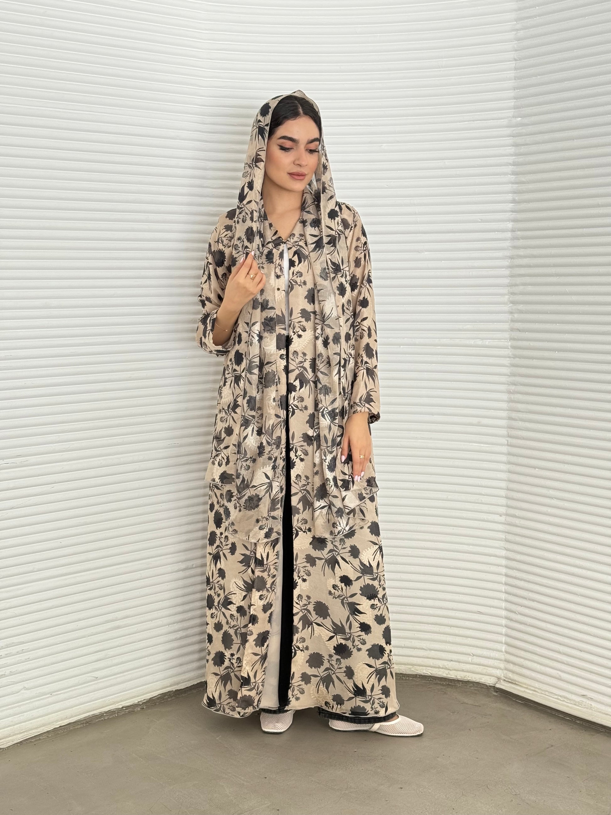 A beige and black floral chiffon abaya, an elegant abaya that is perfect for summer, daytime events, and brunch.