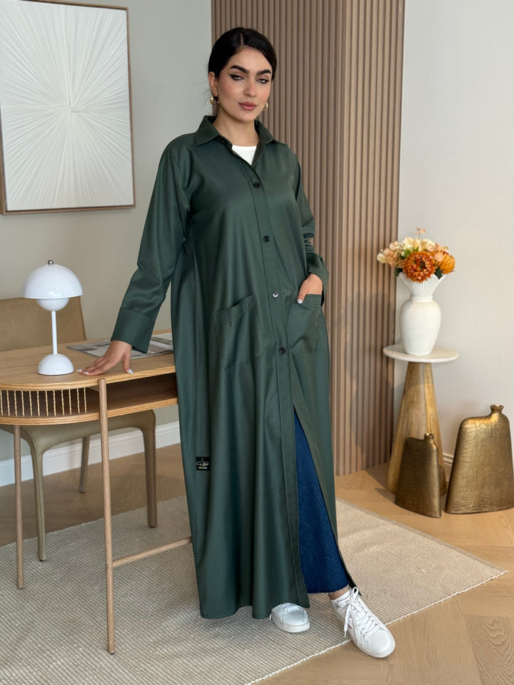 A teal green linen abaya with smart collar and practical pockets, a perfect choice for office wear and everyday wear.
