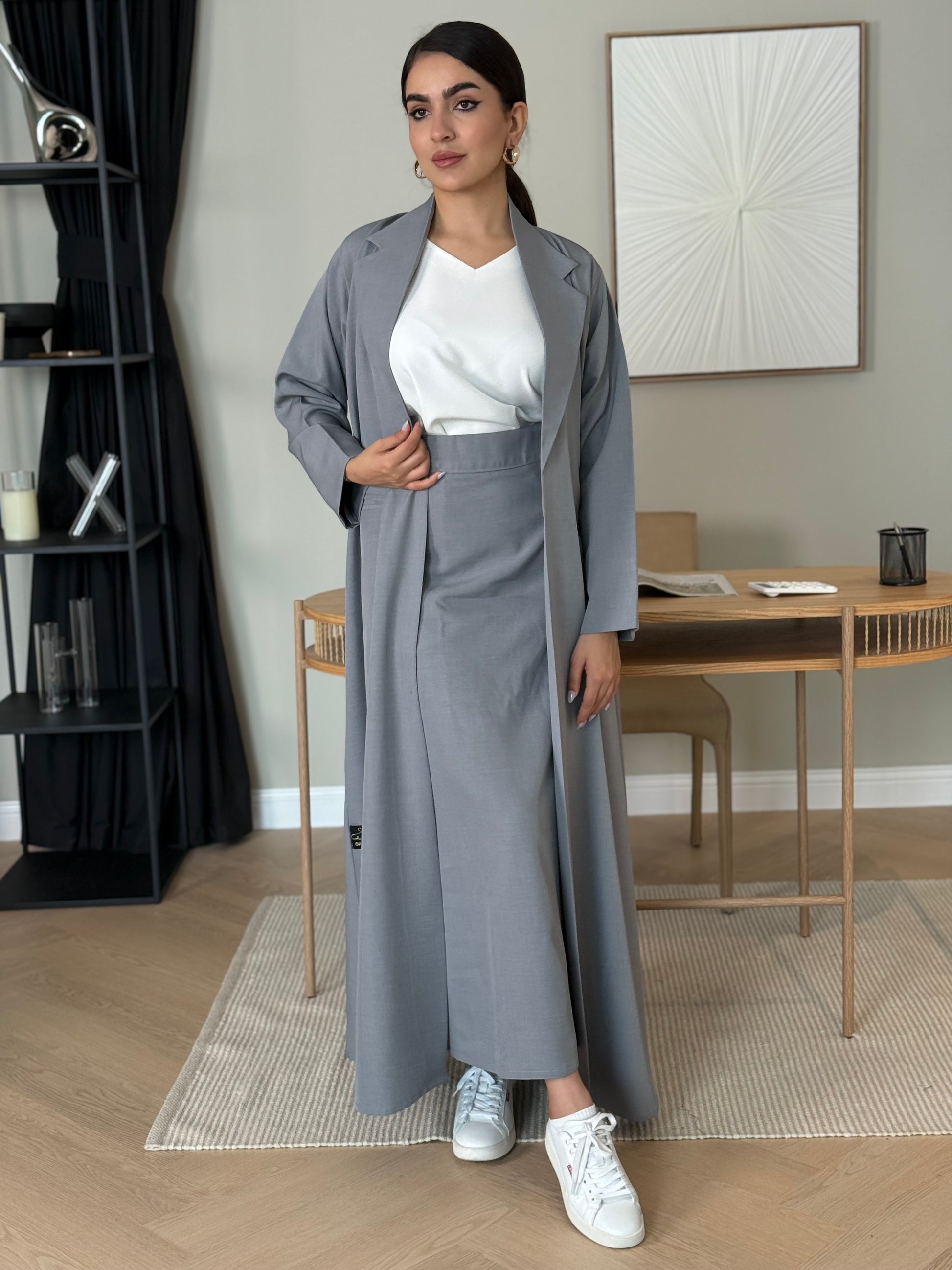 A light grey 3-piece abaya set that includes an open abaya, maxi skirt, inner top and sheila. This abaya is perfect for daytime  events, business settings/meetings or brunch.