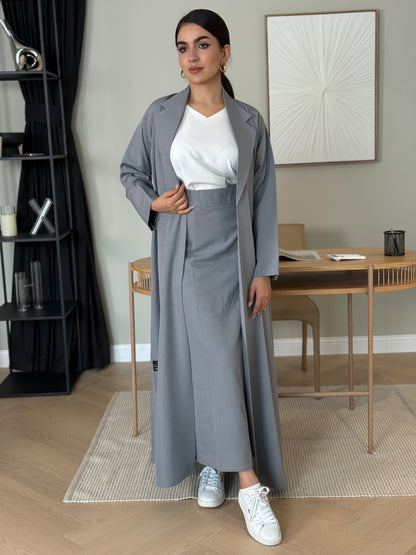 A light grey 3-piece abaya set that includes an open abaya, maxi skirt, inner top and sheila. This abaya is perfect for daytime  events, business settings/meetings or brunch.