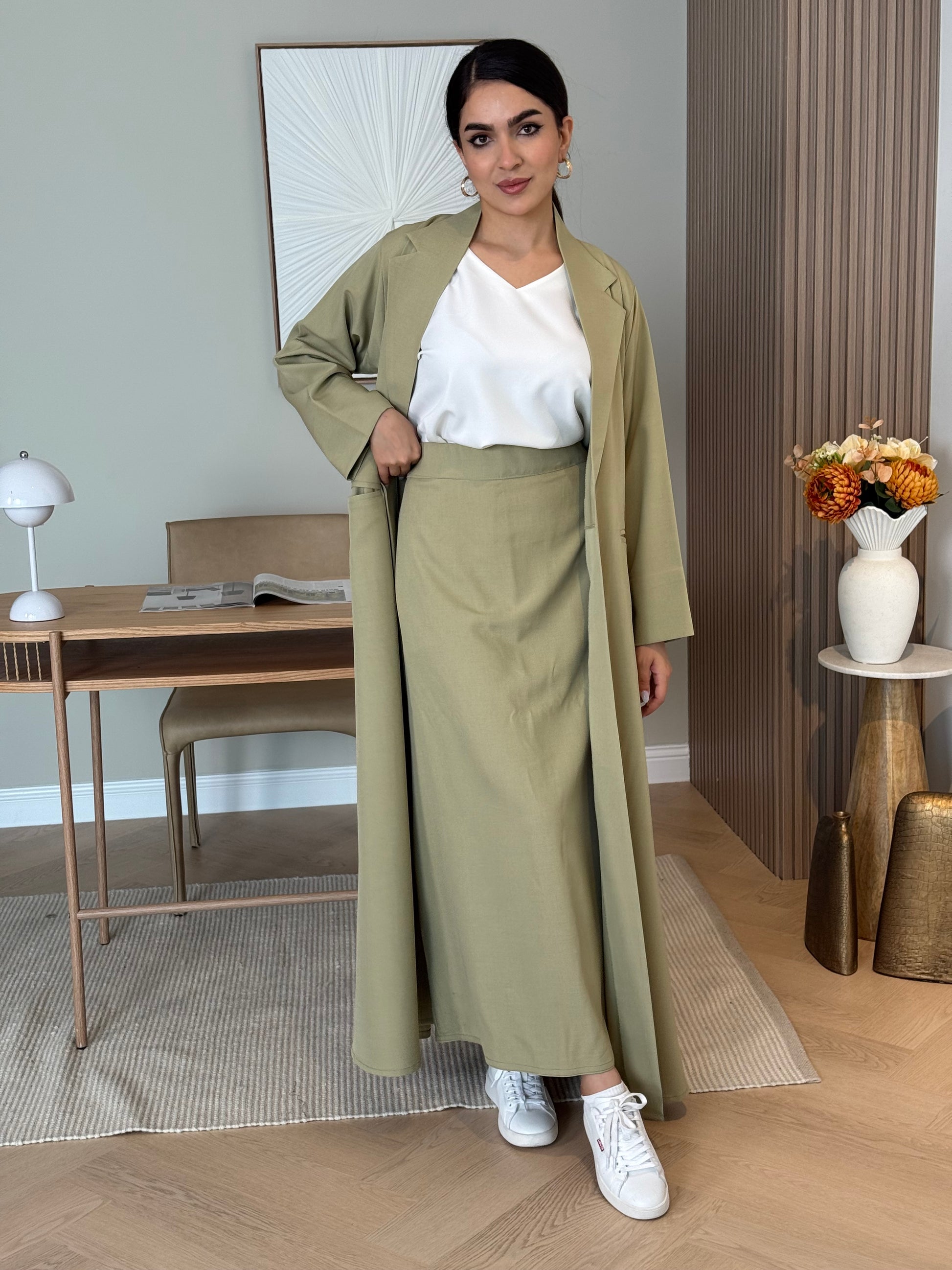 A sage green 3-piece abaya set that includes an open abaya, maxi skirt, inner top and sheila. This abaya is perfect for daytime  events, business settings/meetings or brunch.