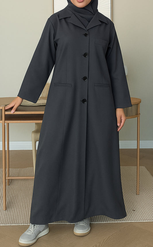 Woman wearing a dark grey Linen Pocket Abaya coat  with a matching sheila in an indoor setting