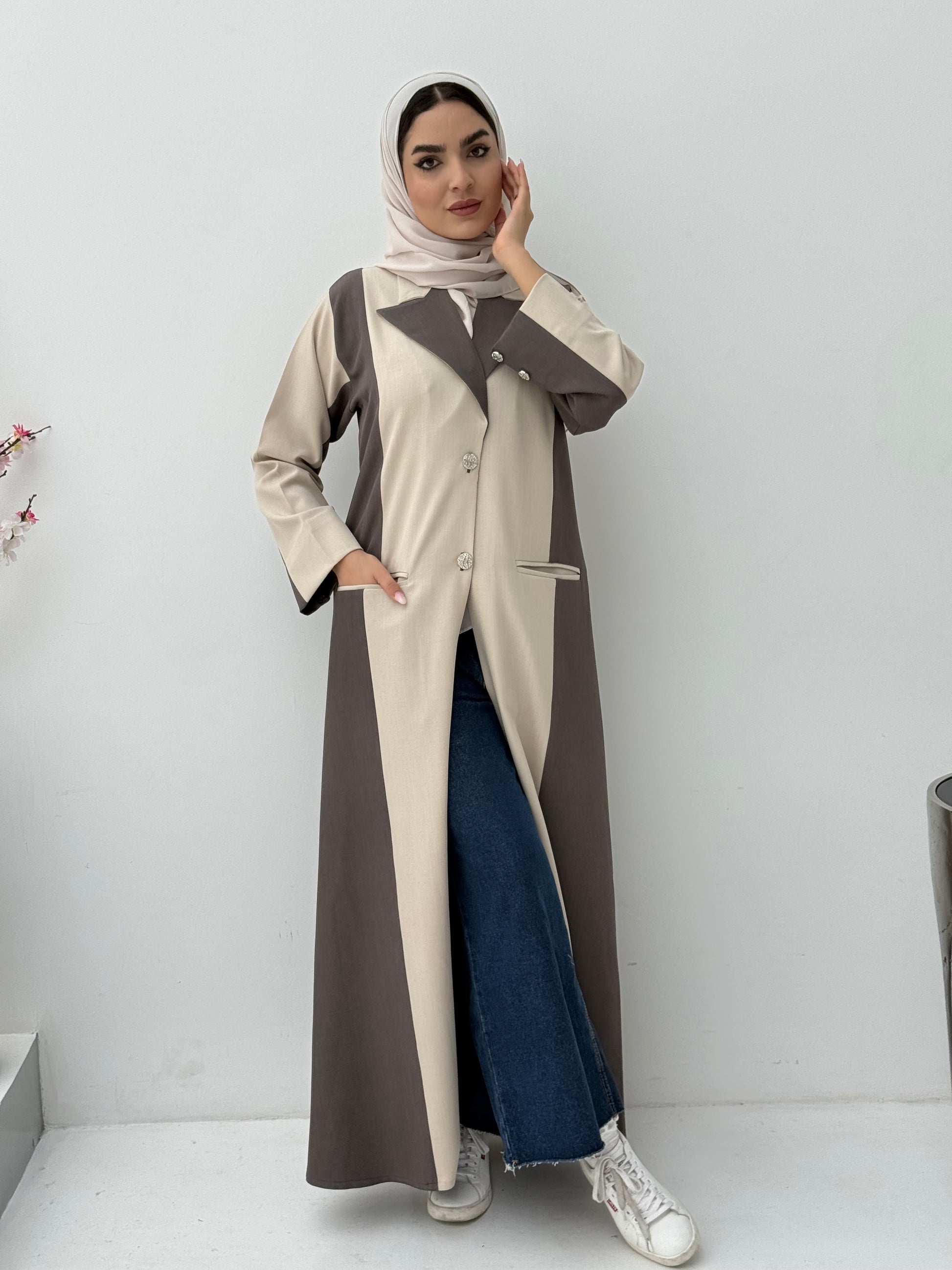 Woman wearing a long, two-tone Beige & Dark Brown Linen Abaya with a matching sheila on a white background