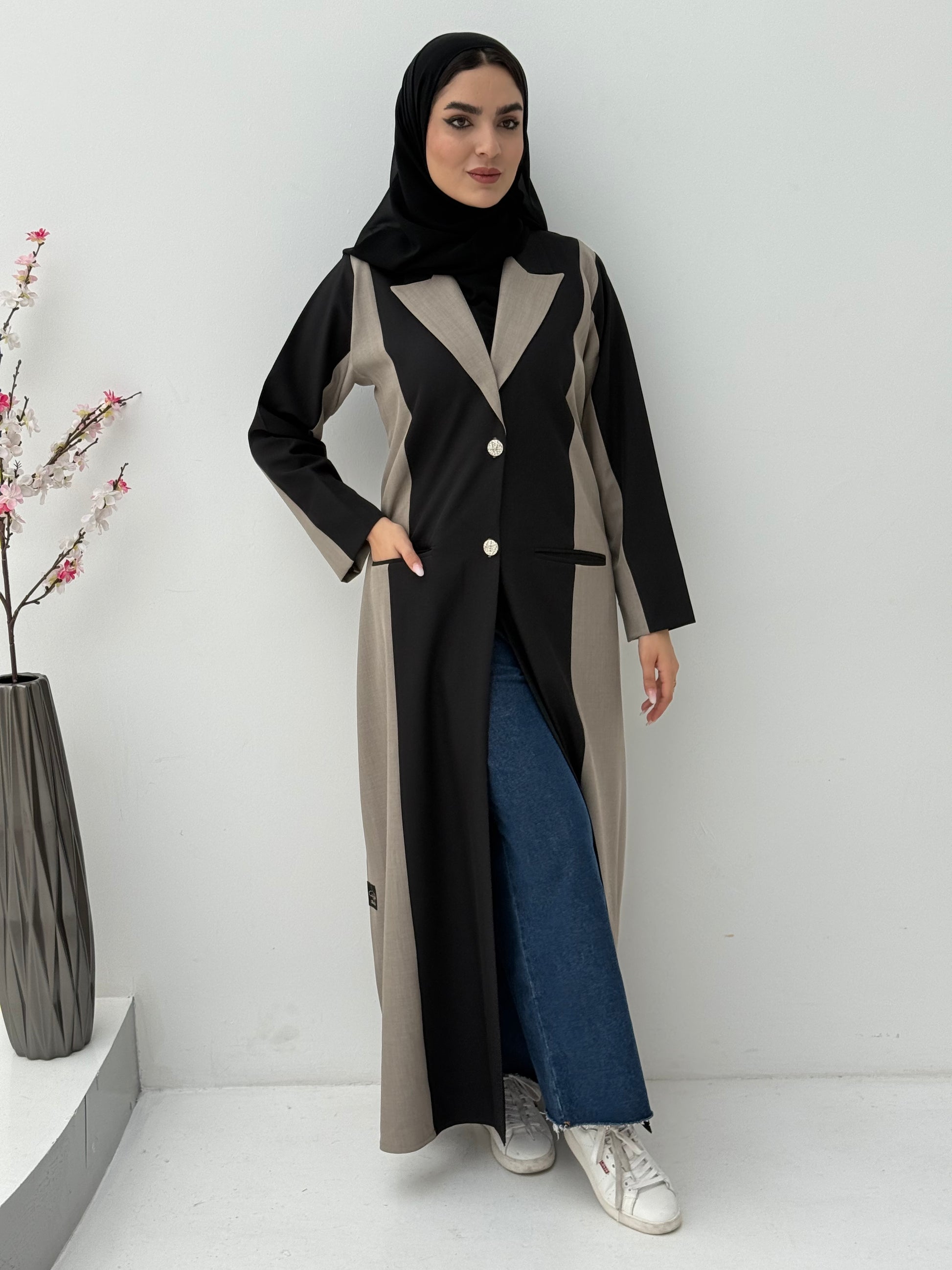 Woman wearing a long, two-tone Black & Beige Linen Abaya with a matching sheila on a white background