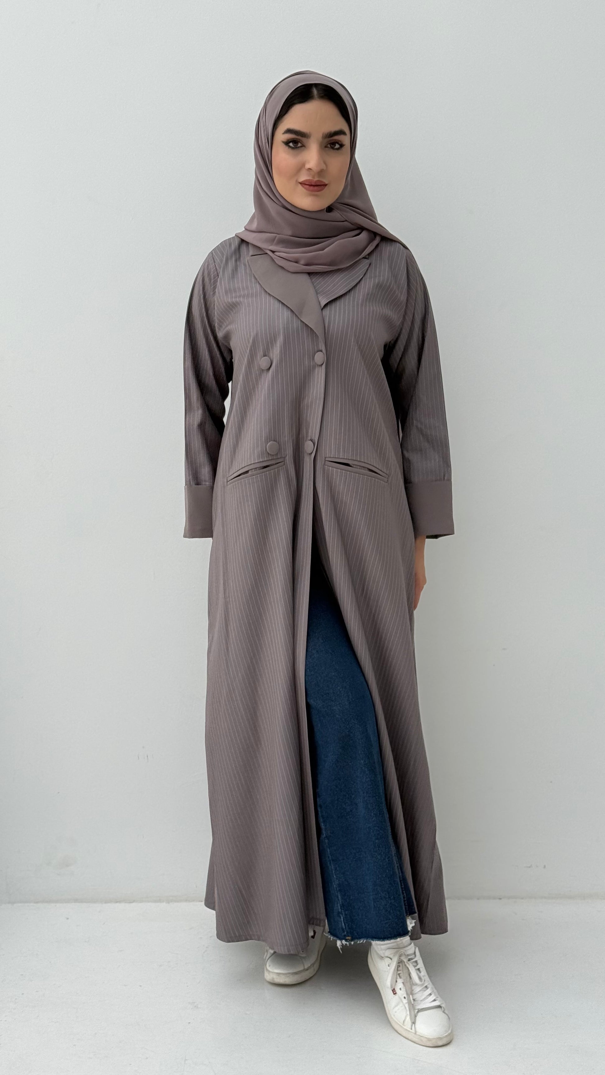 Woman wearing a long Ash Brown Pinstripe Linen Coat Abaya and a matching sheila on a white background