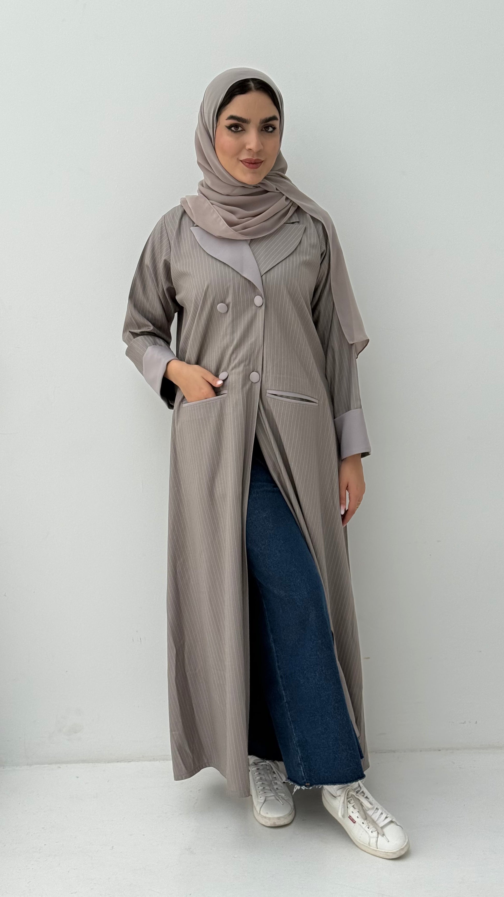 Woman wearing a long Light Beige Pinstripe Linen Coat, Abaya, mathcing sheila hijab on a white background