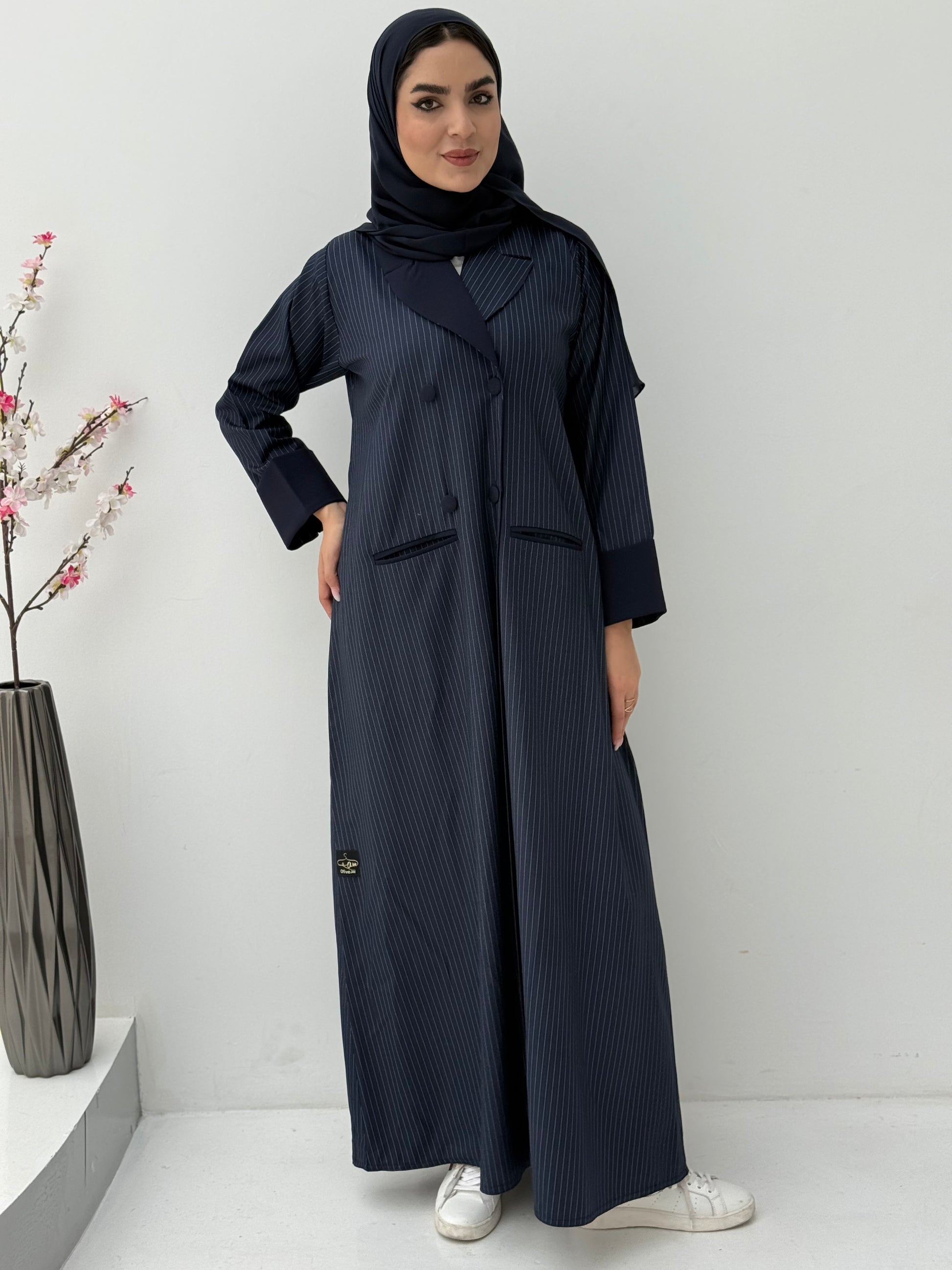 Woman wearing a Navy Blue Pinstripe Linen Coat Abaya with a matching sheila against a white background