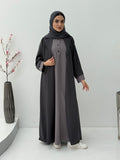 Woman wearing a long Dark Grey & Light Grey Abaya with a matching sheila in a minimalistic setting.