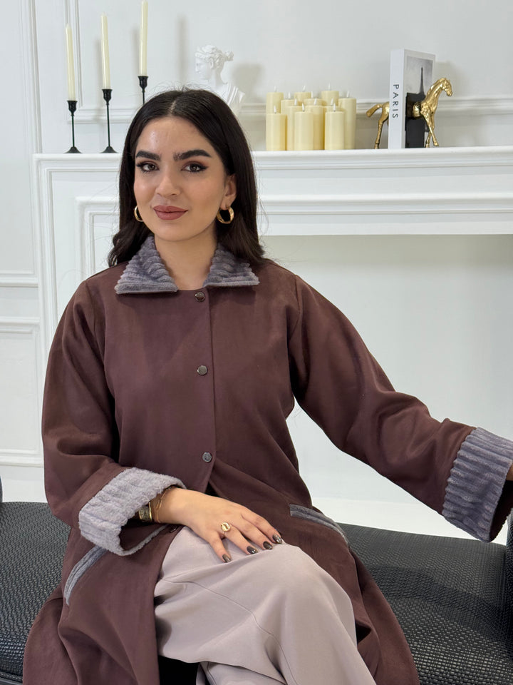 Woman wearing a Burgundy Shamwa Abaya with a gray collar in an indoor setting