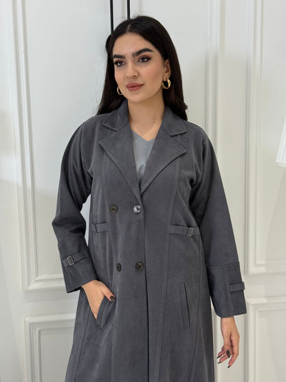 Woman wearing a Dark Grey Shamwa Trench Abaya Set standing against a white wall.