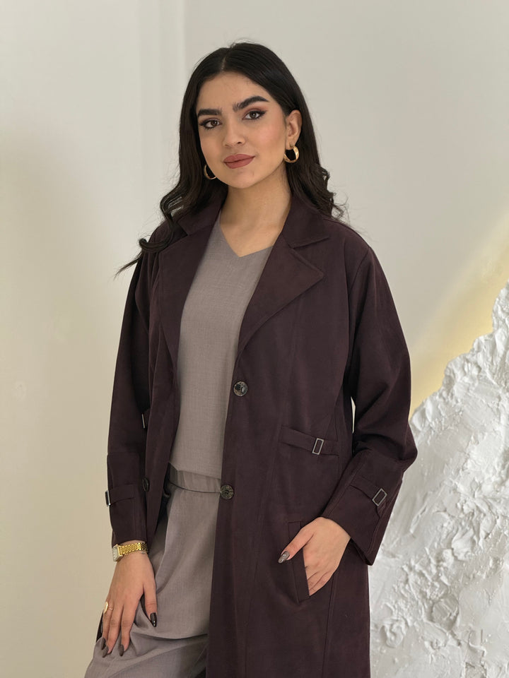Woman wearing a Dark Maroon Shamwa Trench Abaya Set over a gray outfit against a neutral background