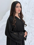 Person wearing a Premium Luxury Hand-Embellished Black Abaya outfit made from Nida fabric, standing on a textured white surface
