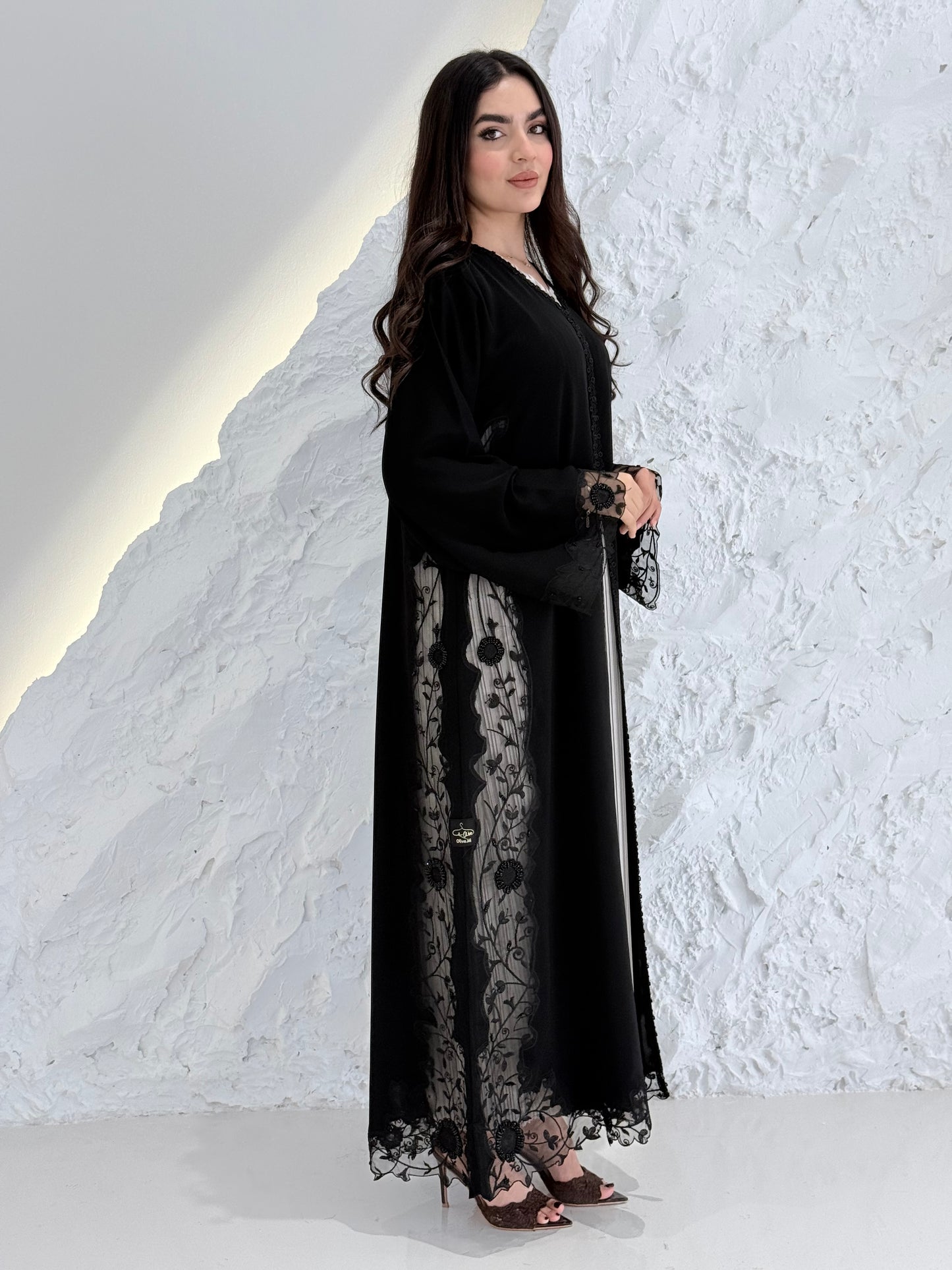 Person wearing a Premium Black Hand-Embellished Abaya made from Nida fabric and Sheer Mesh Panel outfit on a white background