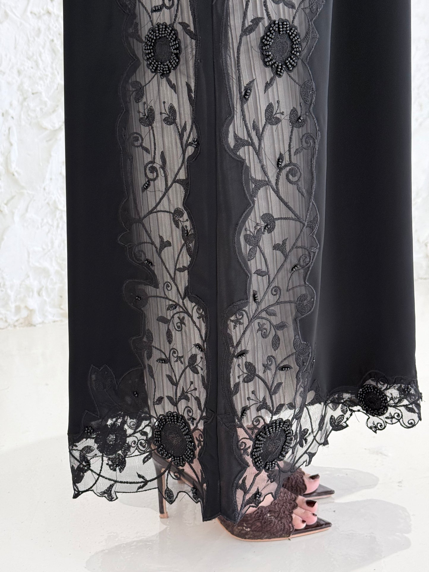 Person wearing a Premium Black Hand-Embellished Abaya made from Nida fabric and Sheer Mesh Panel outfit on a white background