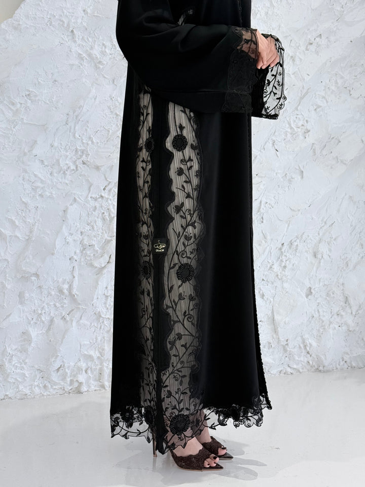 Person wearing a Premium Black Hand-Embellished Abaya made from Nida fabric and Sheer Mesh Panel outfit on a white background