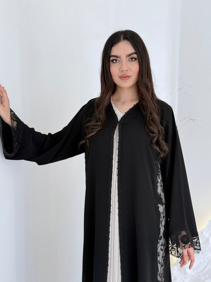 Person wearing a Premium Black Hand-Embellished Abaya made from Nida fabric and Sheer Mesh Panel outfit on a white background