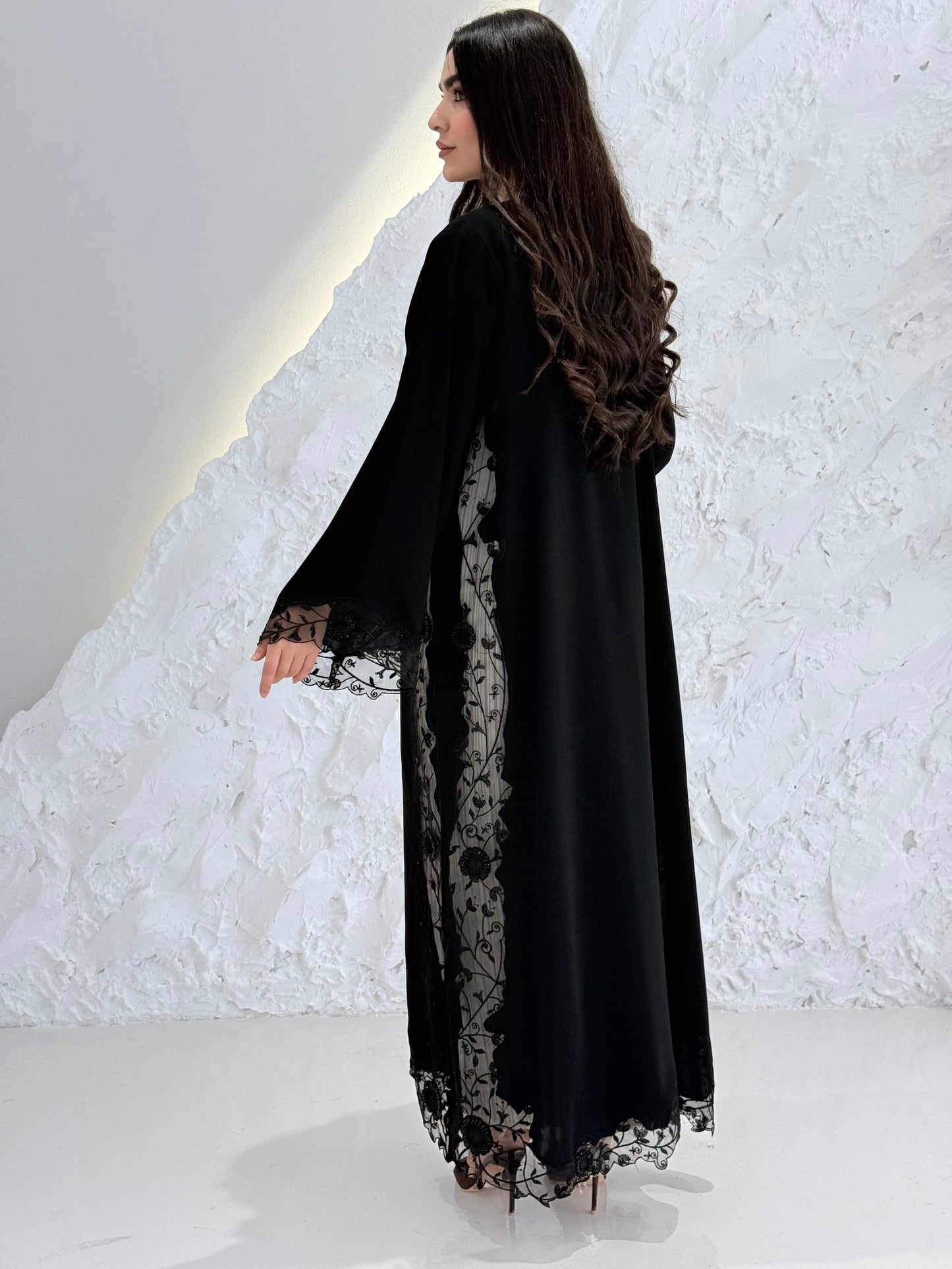 Person wearing a Premium Black Hand-Embellished Abaya made from Nida fabric and Sheer Mesh Panel outfit on a white background