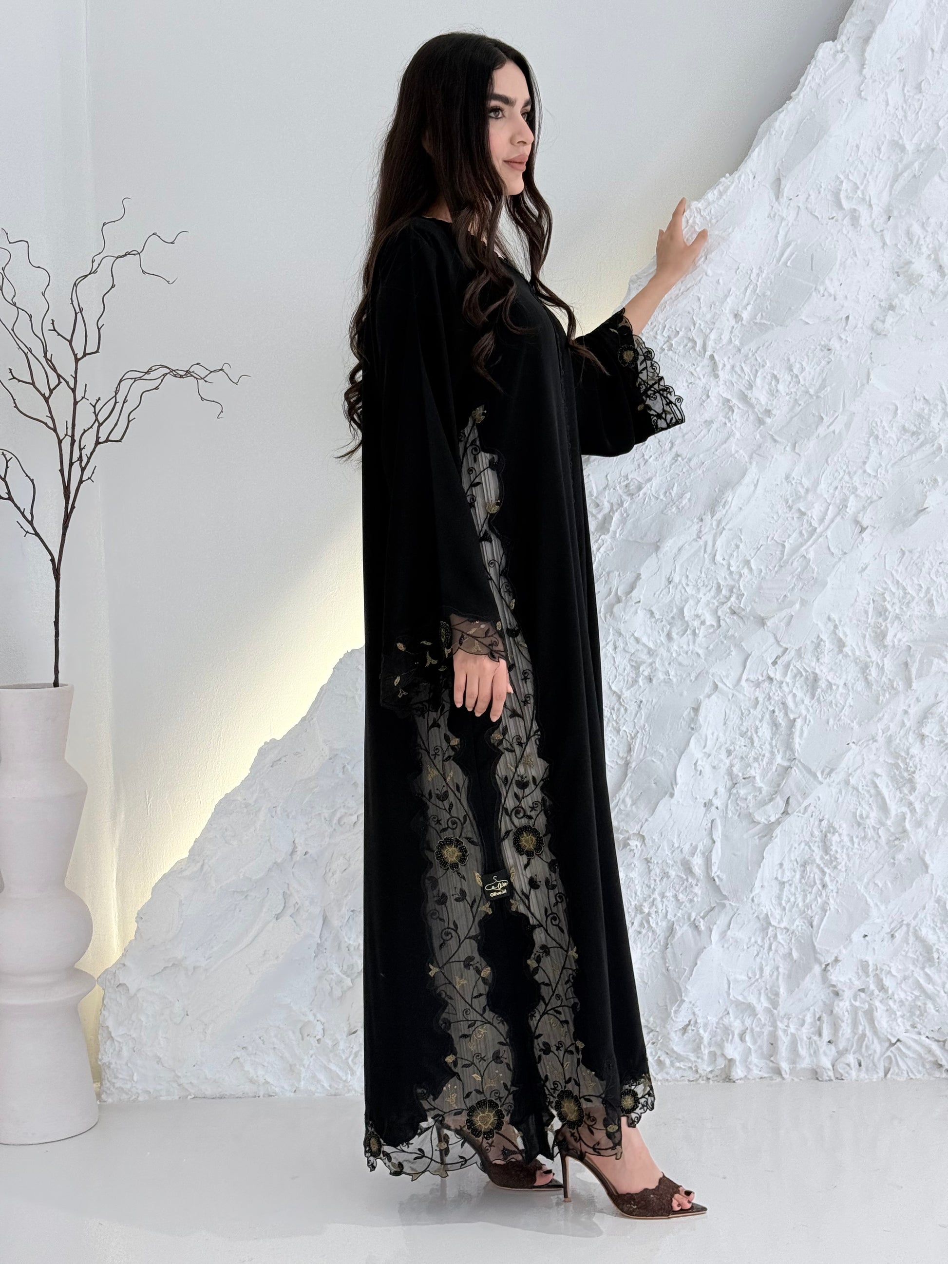 Person wearing a Premium Gold Hand-Embellished Abaya made from Nida fabric and Sheer Mesh Panel outfit on a white background