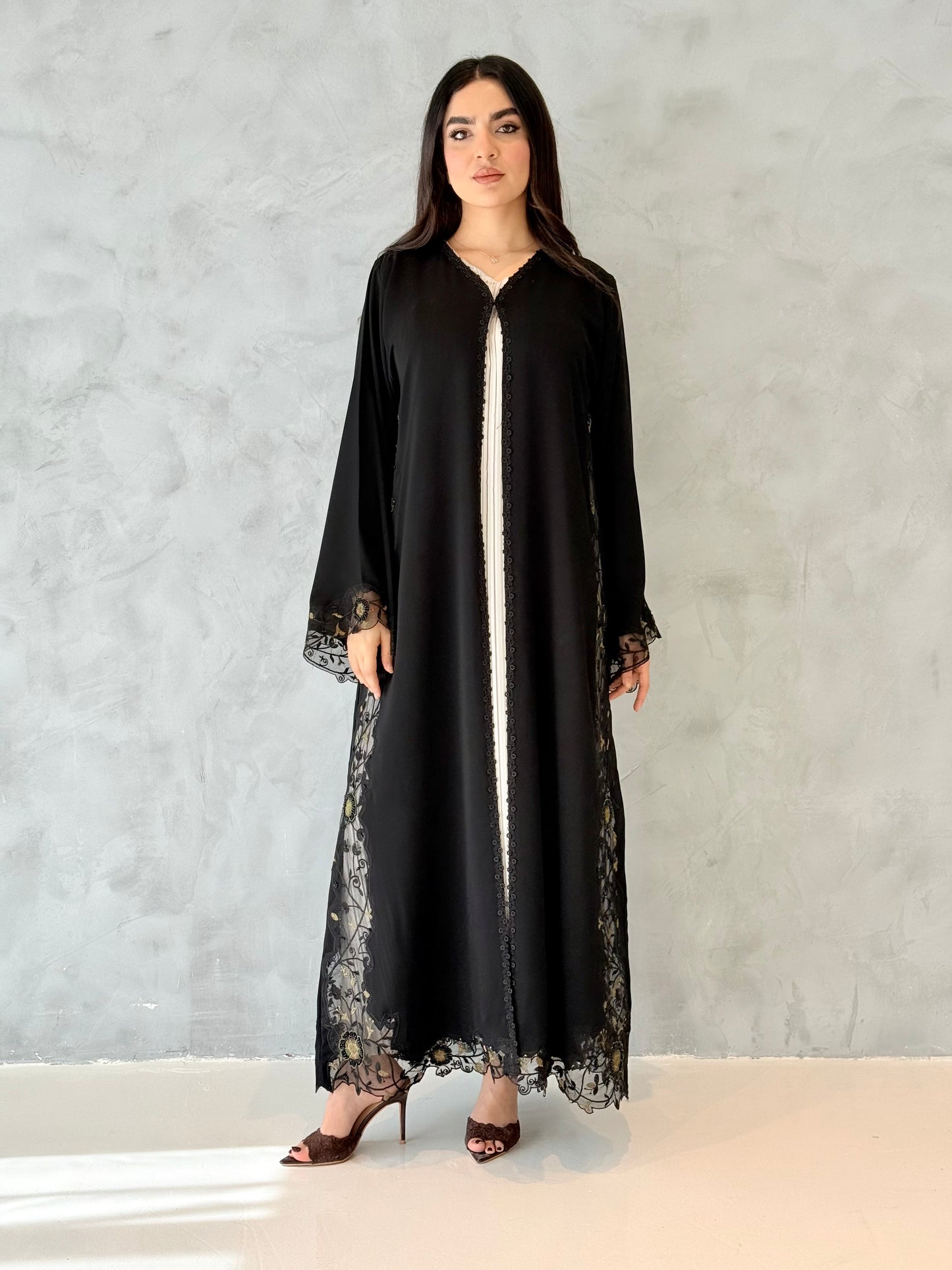 Person wearing a Premium Gold Hand-Embellished Abaya made from Nida fabric and Sheer Mesh Panel outfit on a white background