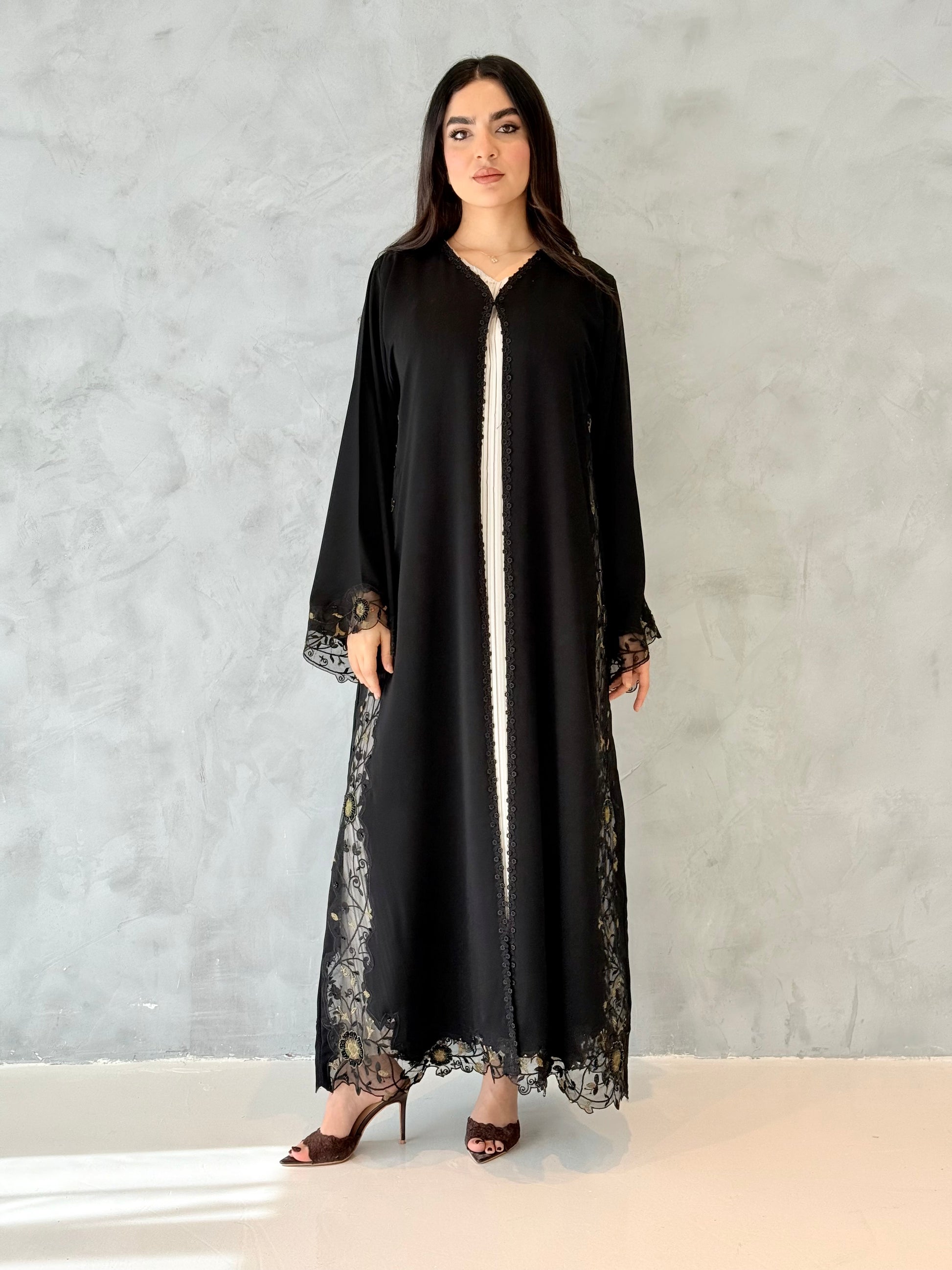 Person wearing a Premium Gold Hand-Embellished Abaya made from Nida fabric and Sheer Mesh Panel outfit on a white background