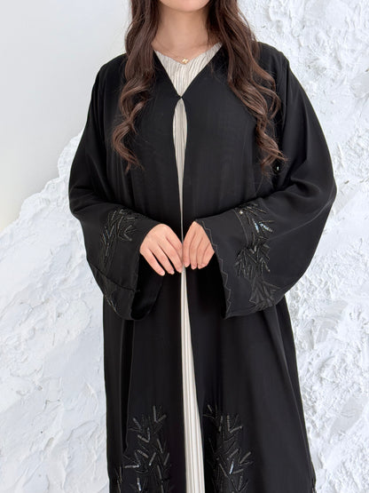 Woman in a long Premium Black Hand-Embellished Chiffon Abaya standing on a snowy landscape