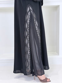 Woman wearing a  Premium Black Abaya with Silver Plissé Panel on a light gray background