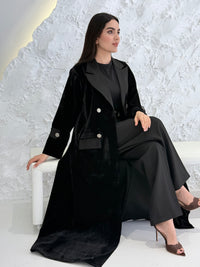 Woman wearing a Premium Black Velvet  coat abaya on a light gray background