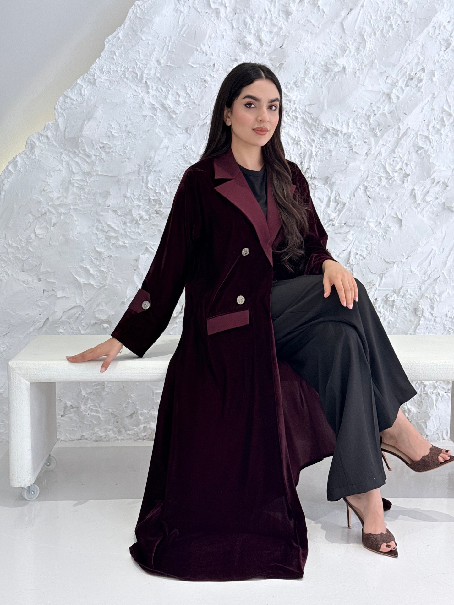 Woman wearing a Premium maroon Velvet coat abaya on a light gray background