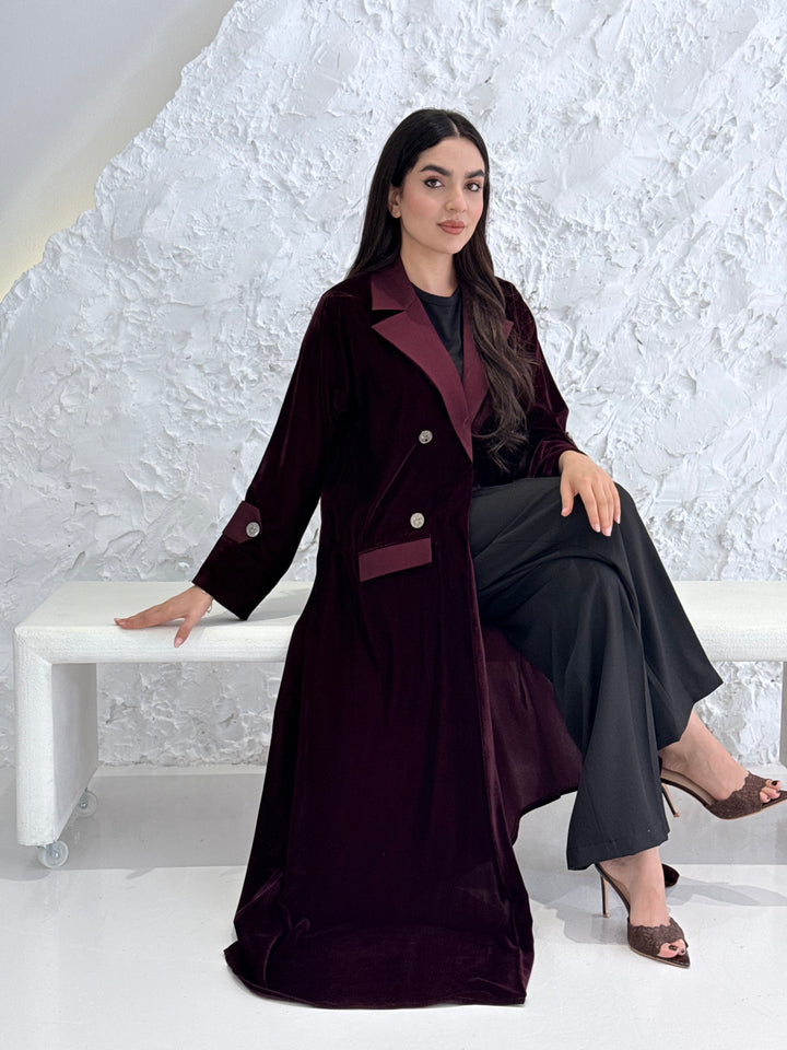 Woman wearing a Premium maroon Velvet coat abaya on a light gray background