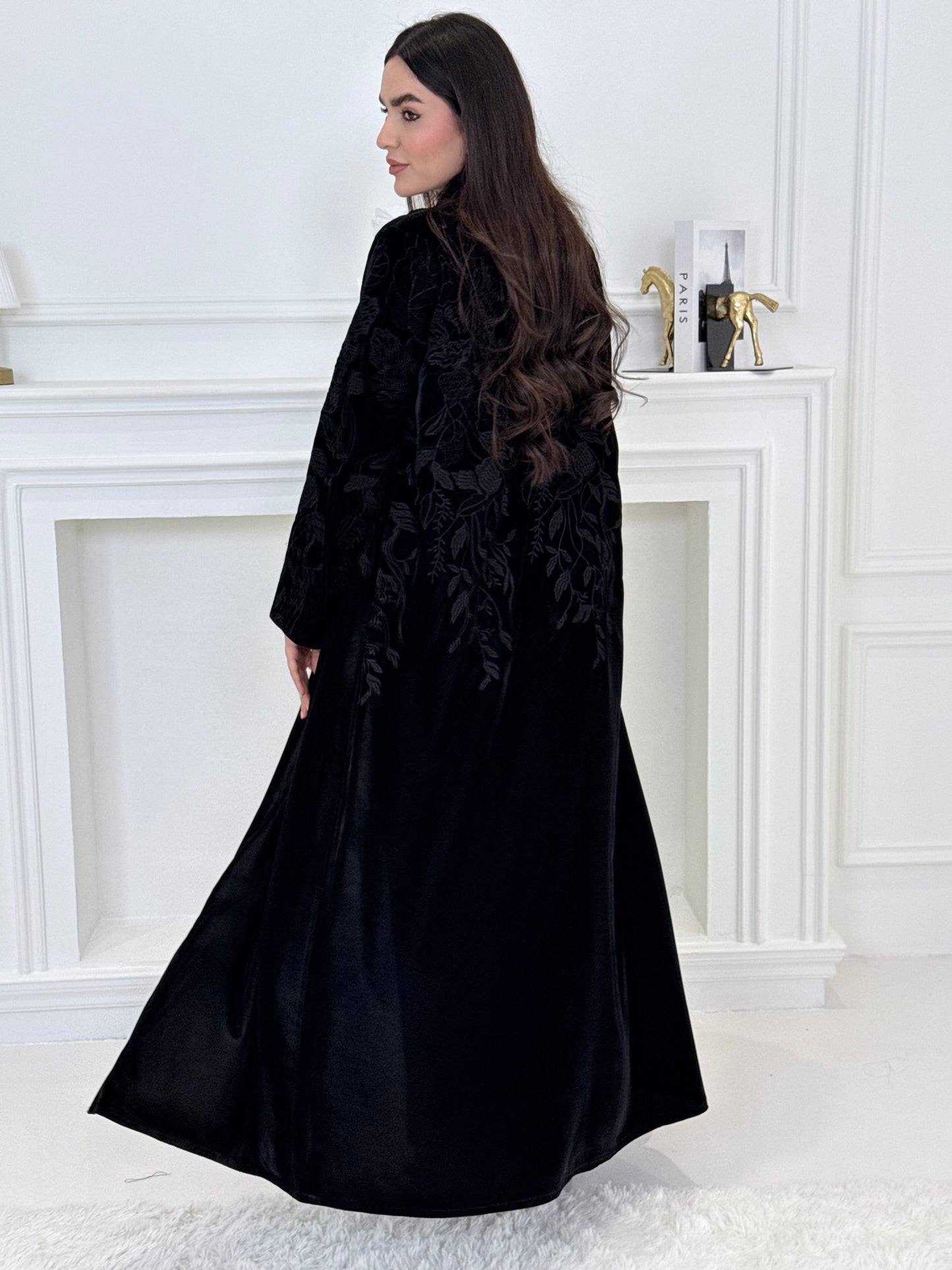 Woman wearing a Black Embroidered Velvet Abaya coat with a white background