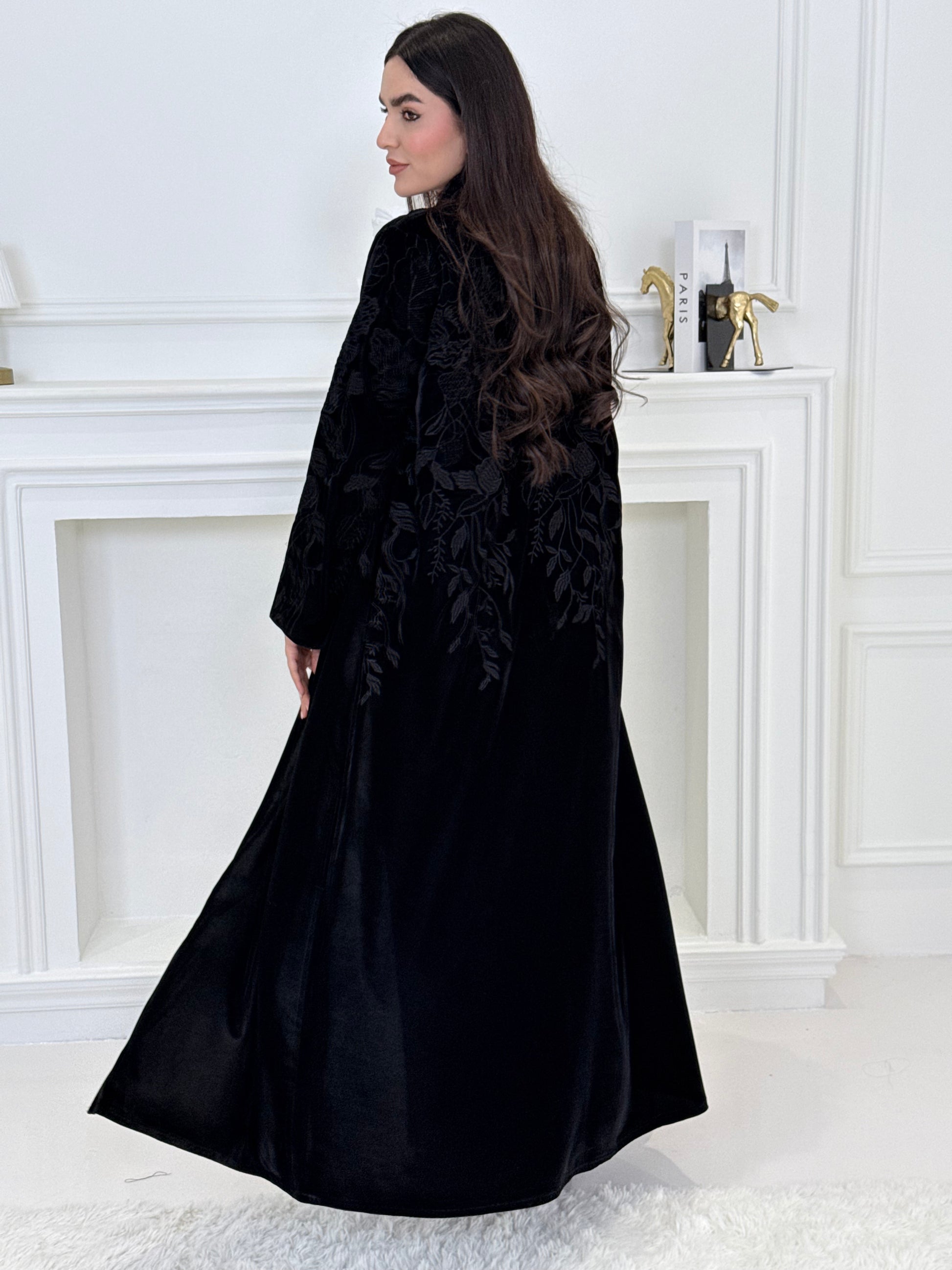 Woman wearing a Black Embroidered Velvet Abaya coat with a white background