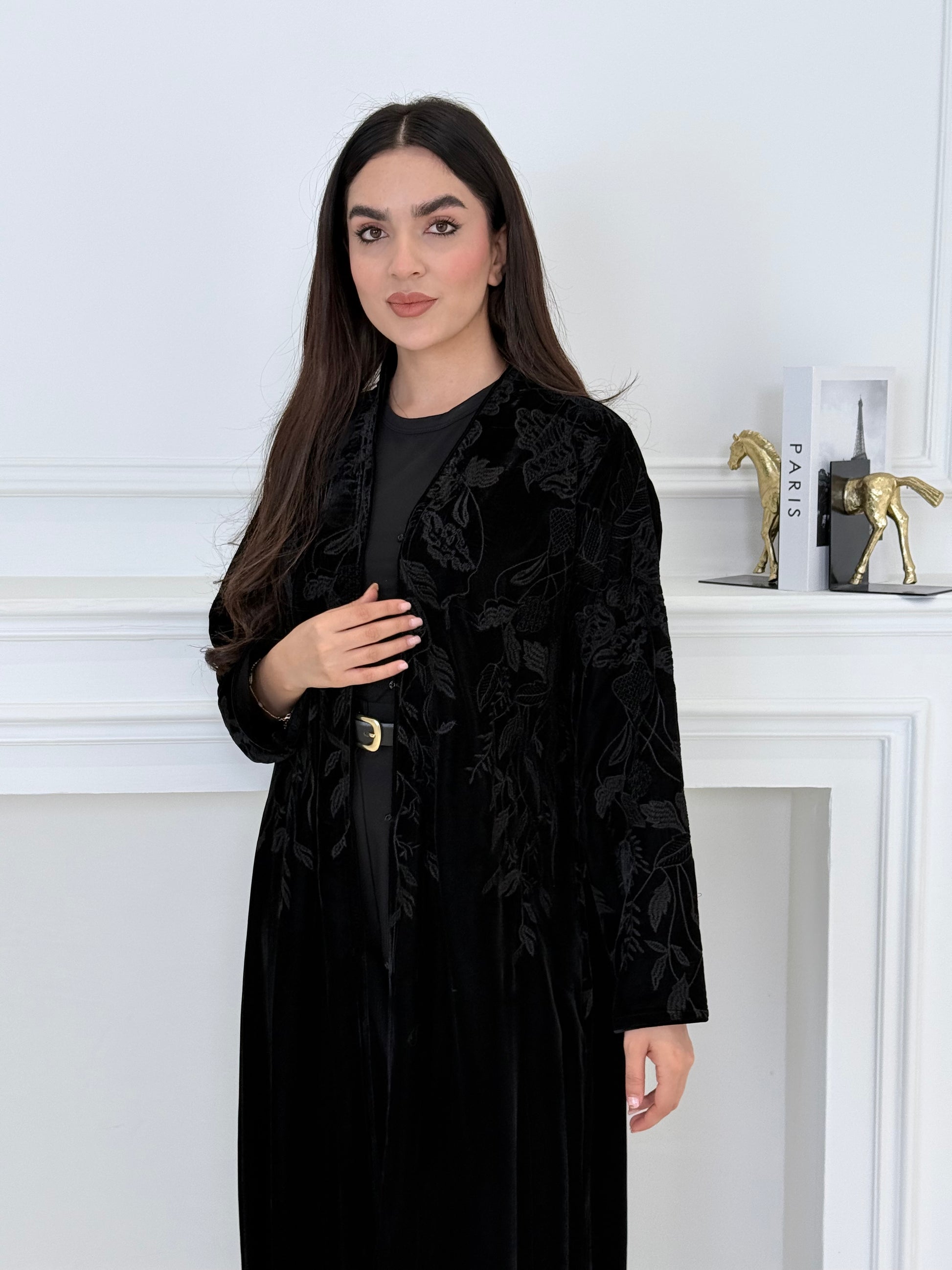 Woman wearing a Black Embroidered Velvet Abaya coat with a white background