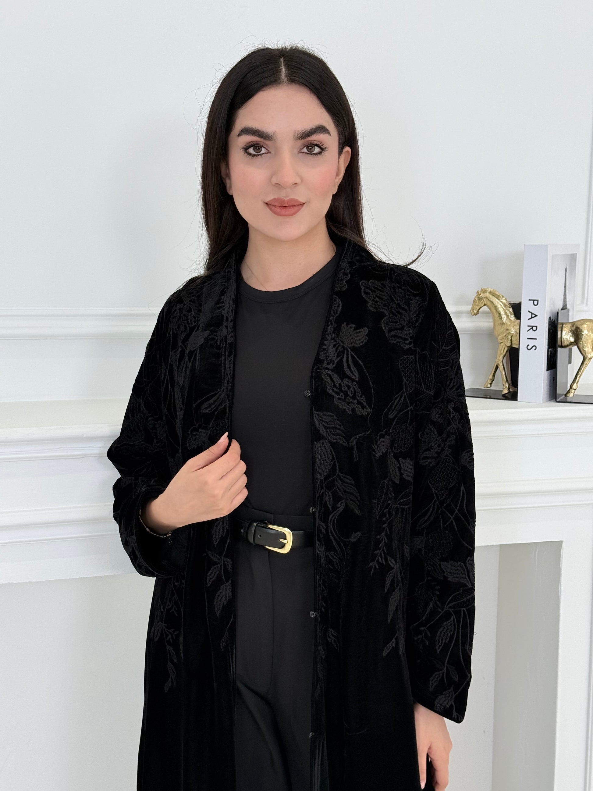 Woman wearing a Black Embroidered Velvet Abaya coat with a white background