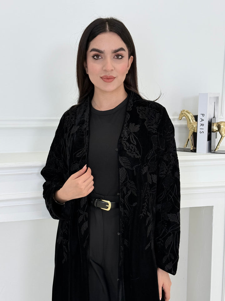 Woman wearing a Black Embroidered Velvet Abaya coat with a white background