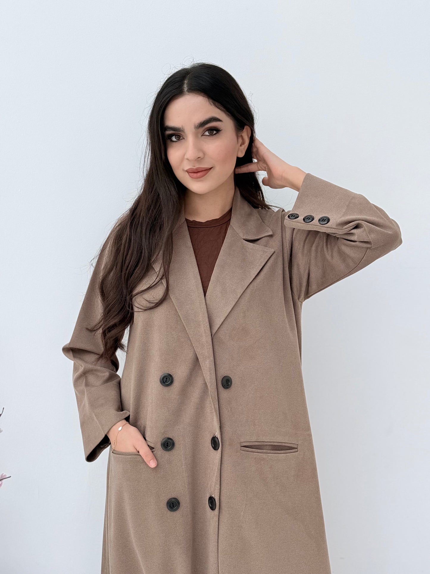 Woman wearing a Premium  beige Shamwa coat abaya against a white background