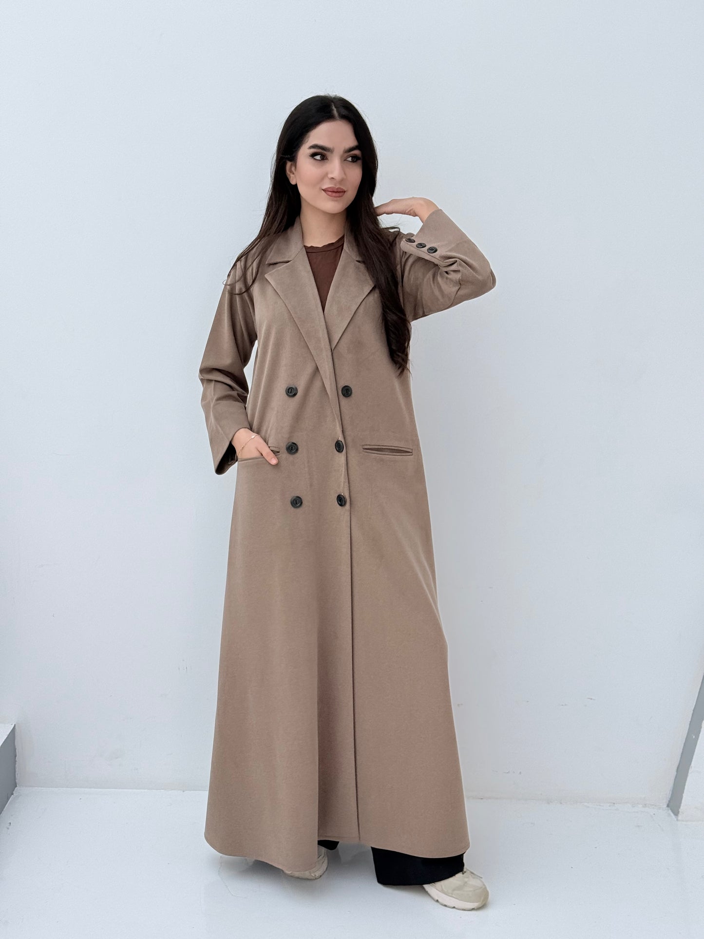 Woman wearing a Premium  beige Shamwa coat abaya against a white background