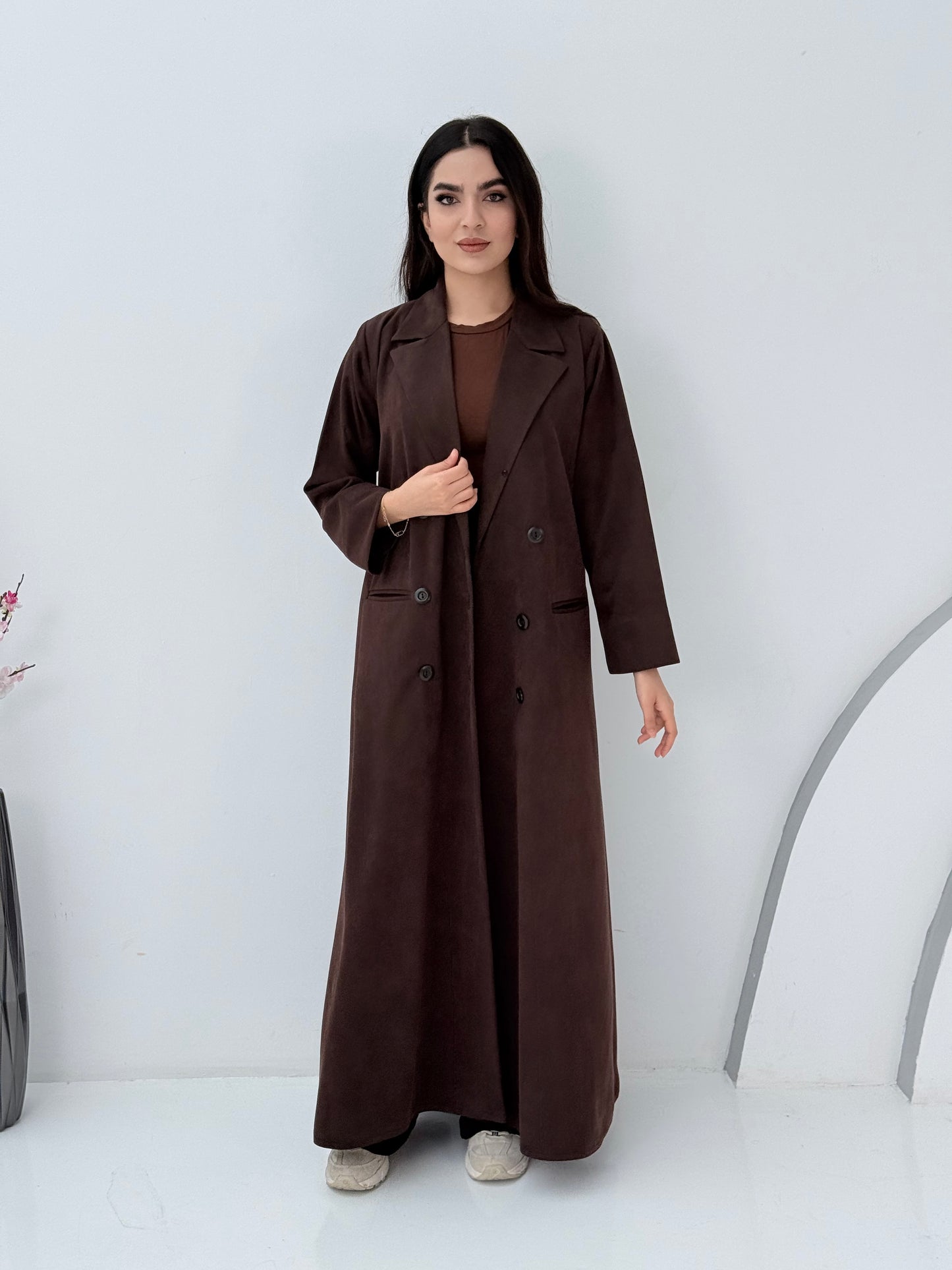 Woman wearing a Premium dark brown Shamwa coat abaya against a white background