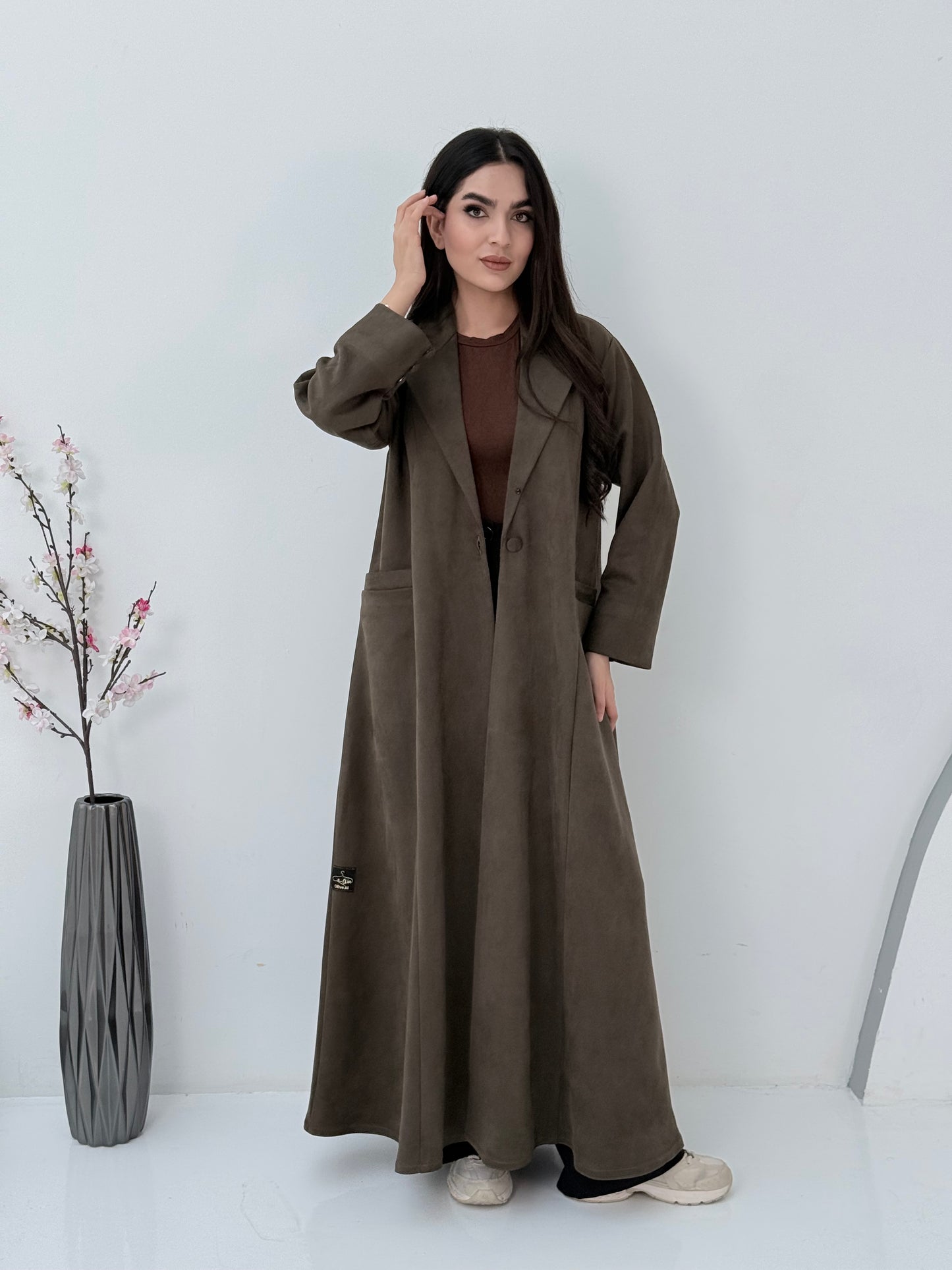 Woman wearing a Premium dark olive Shamwa Coat Abaya on a white background