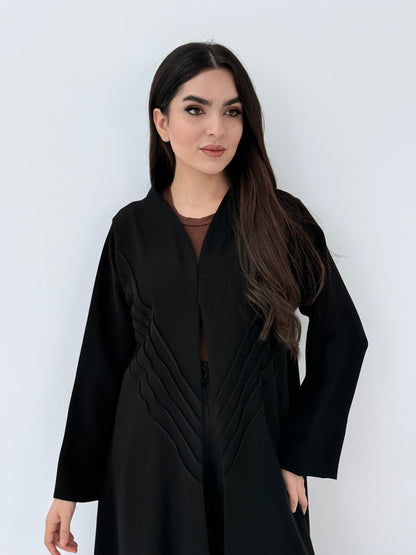 Woman wearing a long Premium black Crepe Abaya with Pleated Waist dress on a white background
