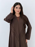 Woman wearing a long Premium dark brown Crepe Abaya with Pleated Waist dress on a white background