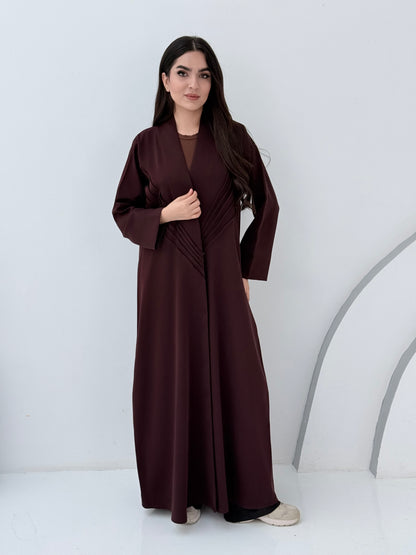 Woman wearing a long Premium burgundy Maroon Crepe Abaya with Pleated Waist dress on a white background