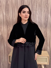 Woman in a Premium black velvet Crepe and Velvet abaya on a wooden background