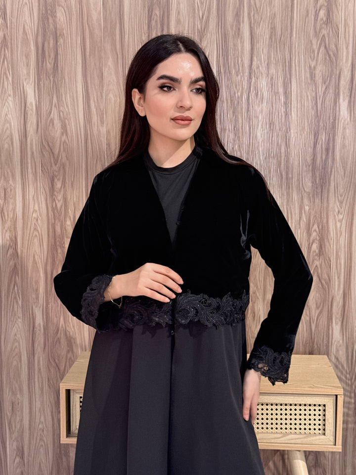 Woman in a Premium black velvet Crepe and Velvet abaya on a wooden background