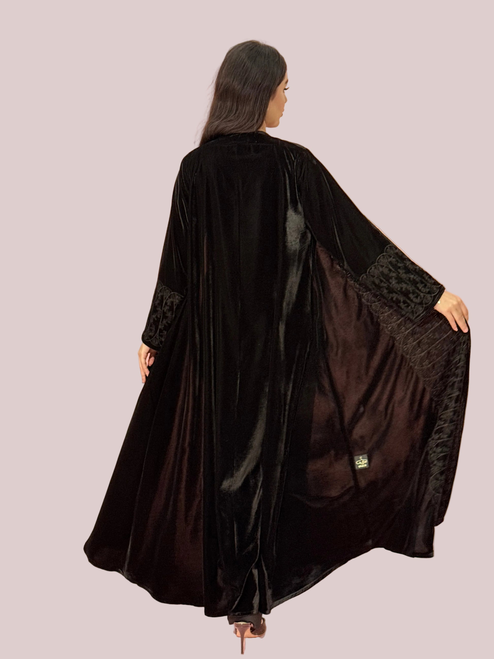Premium Black Velvet Abaya with Front Embroideryon a pink background
