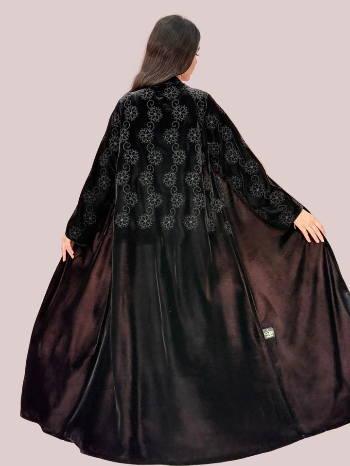 Embroidered Premium Black Velvet Abaya against a pink background